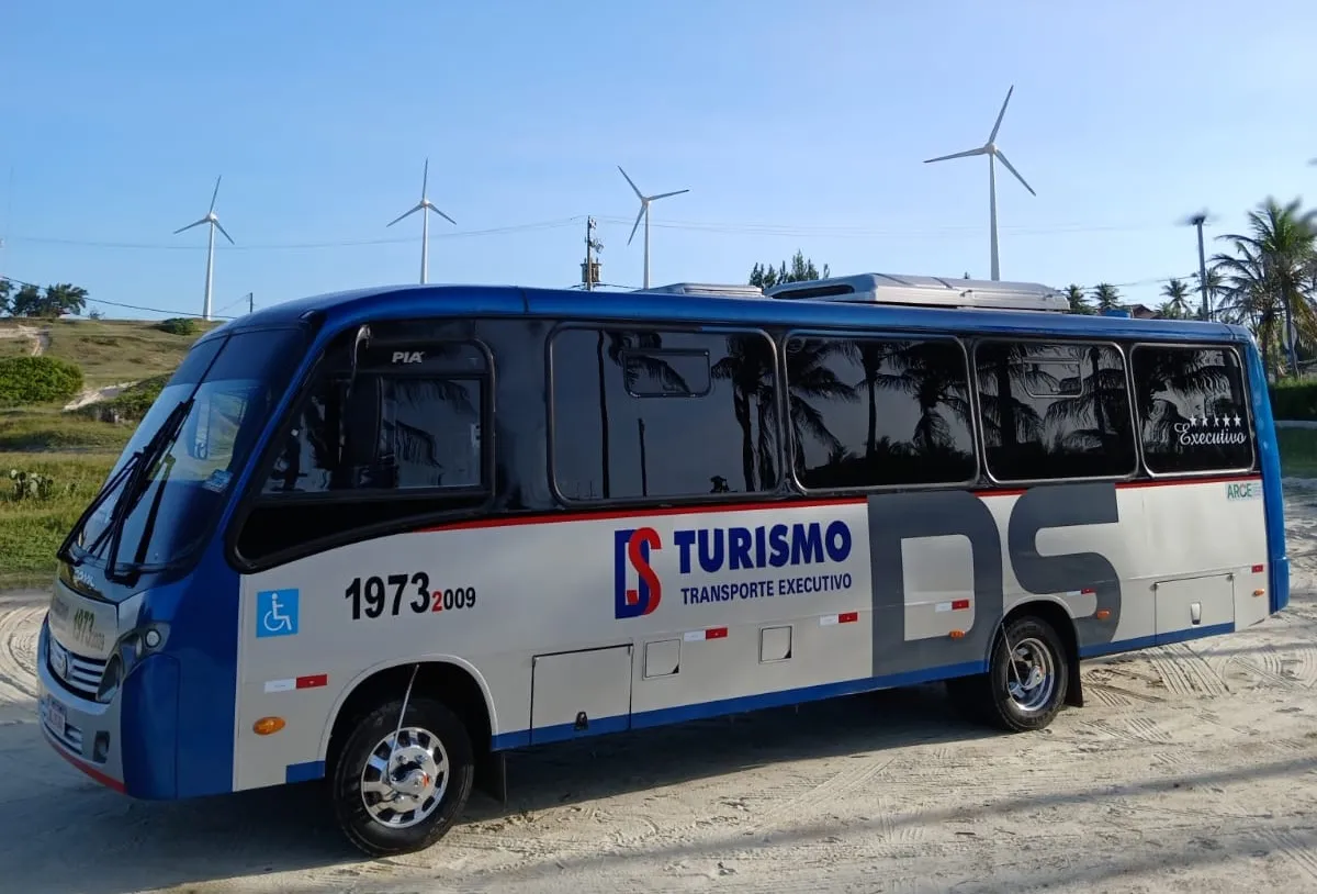 Micro-ônibus passando por parque eólico